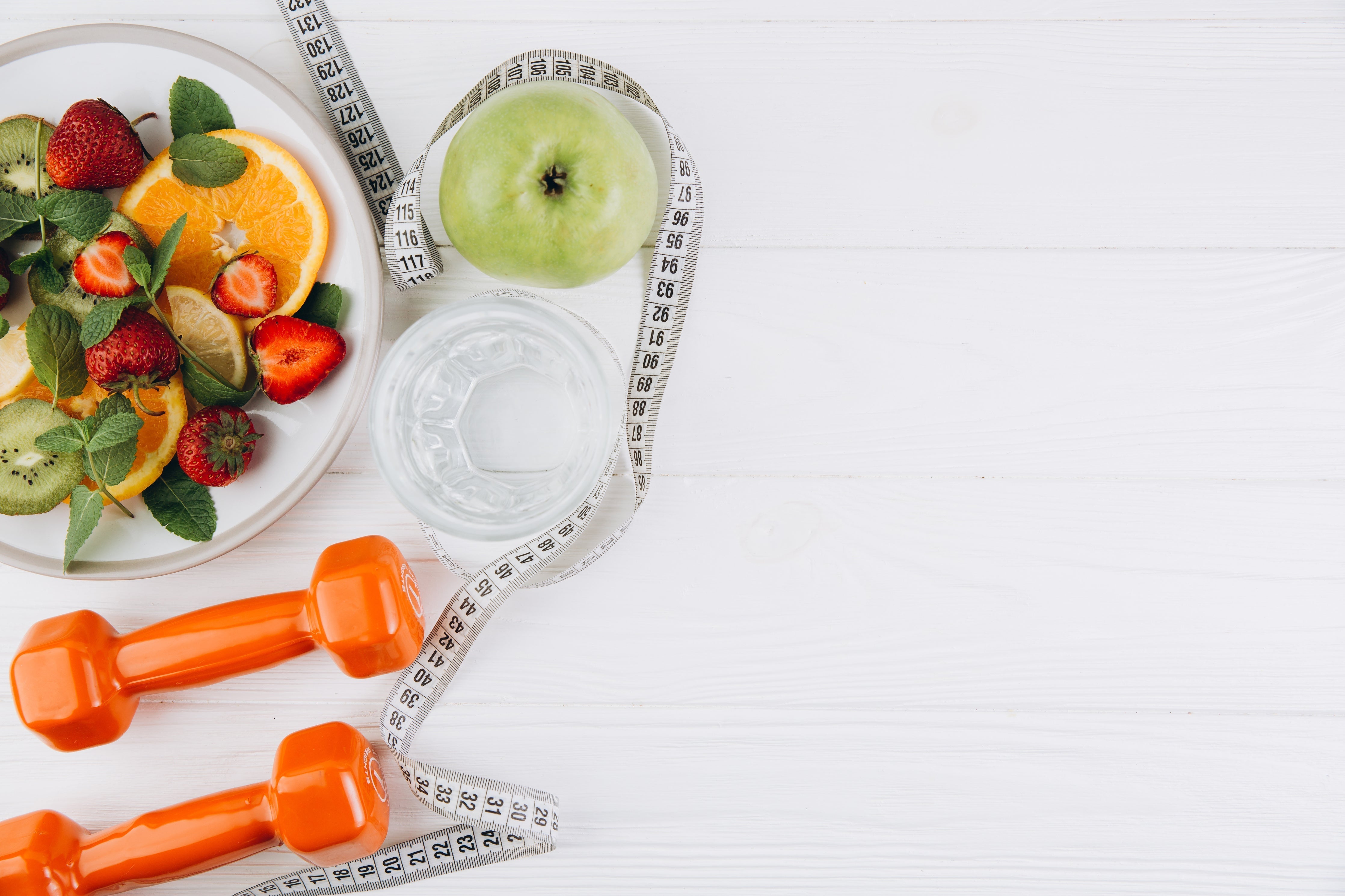 weights, plate with food and fruits