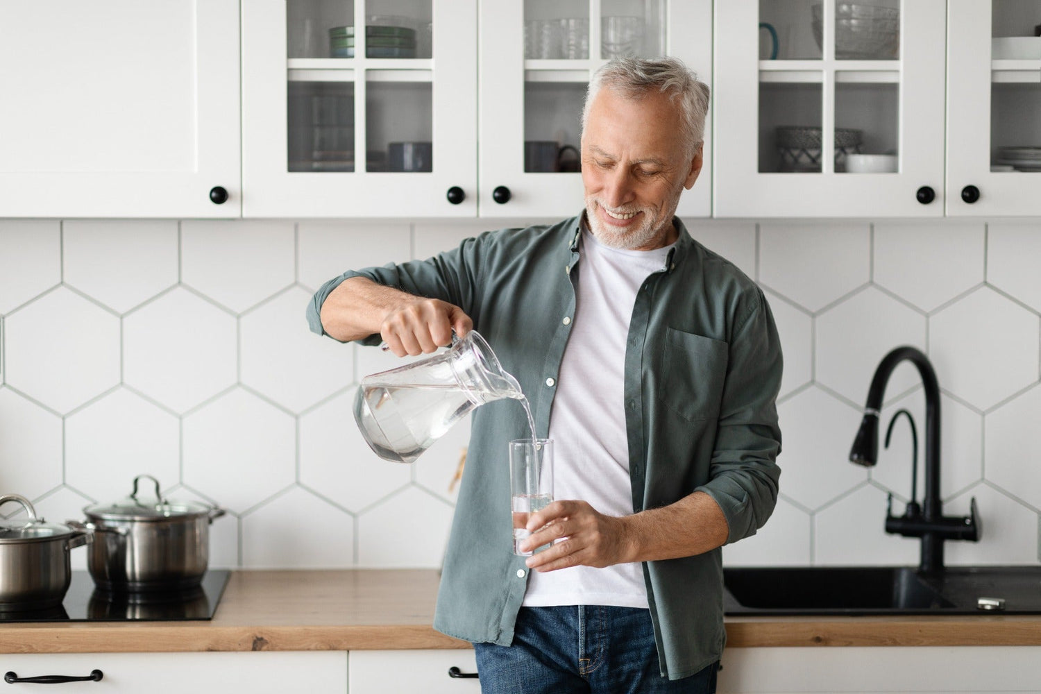 man pouring himself a glass of water