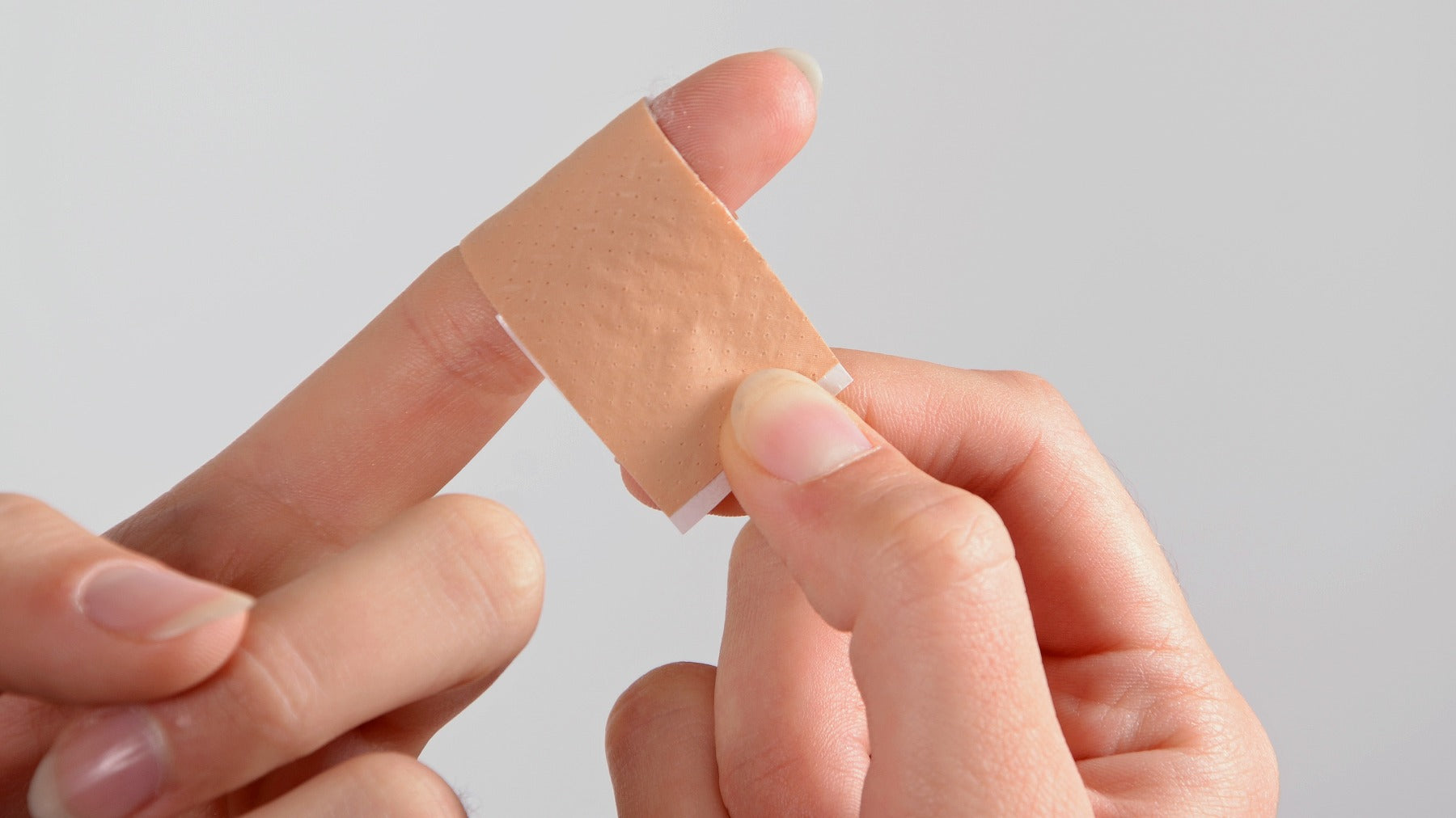 person putting bandage around finger