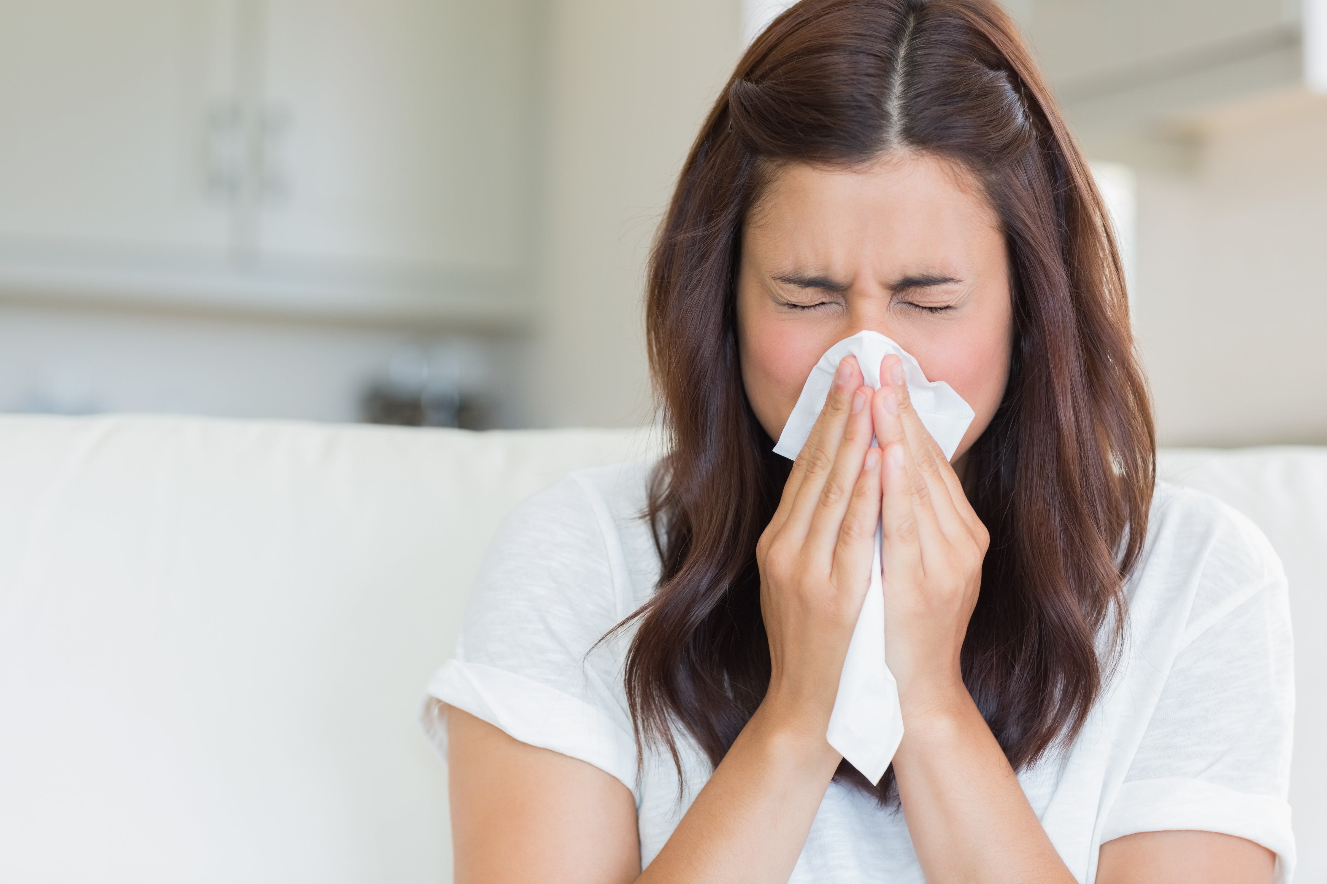 woman sneezing in a tissue